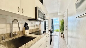 A modern kitchen with granite countertops, stainless steel appliances, and a view of the sea. - A Private Space by Villa Sunbeam. (St. Thomas)