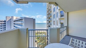 A balcony with a view of the ocean, white furniture, and a building with balconies in the background. - Ocean view 3 BR/3BA condo!  Royale Palms 12th floor! Perfect for families! (Myrtle Beach)