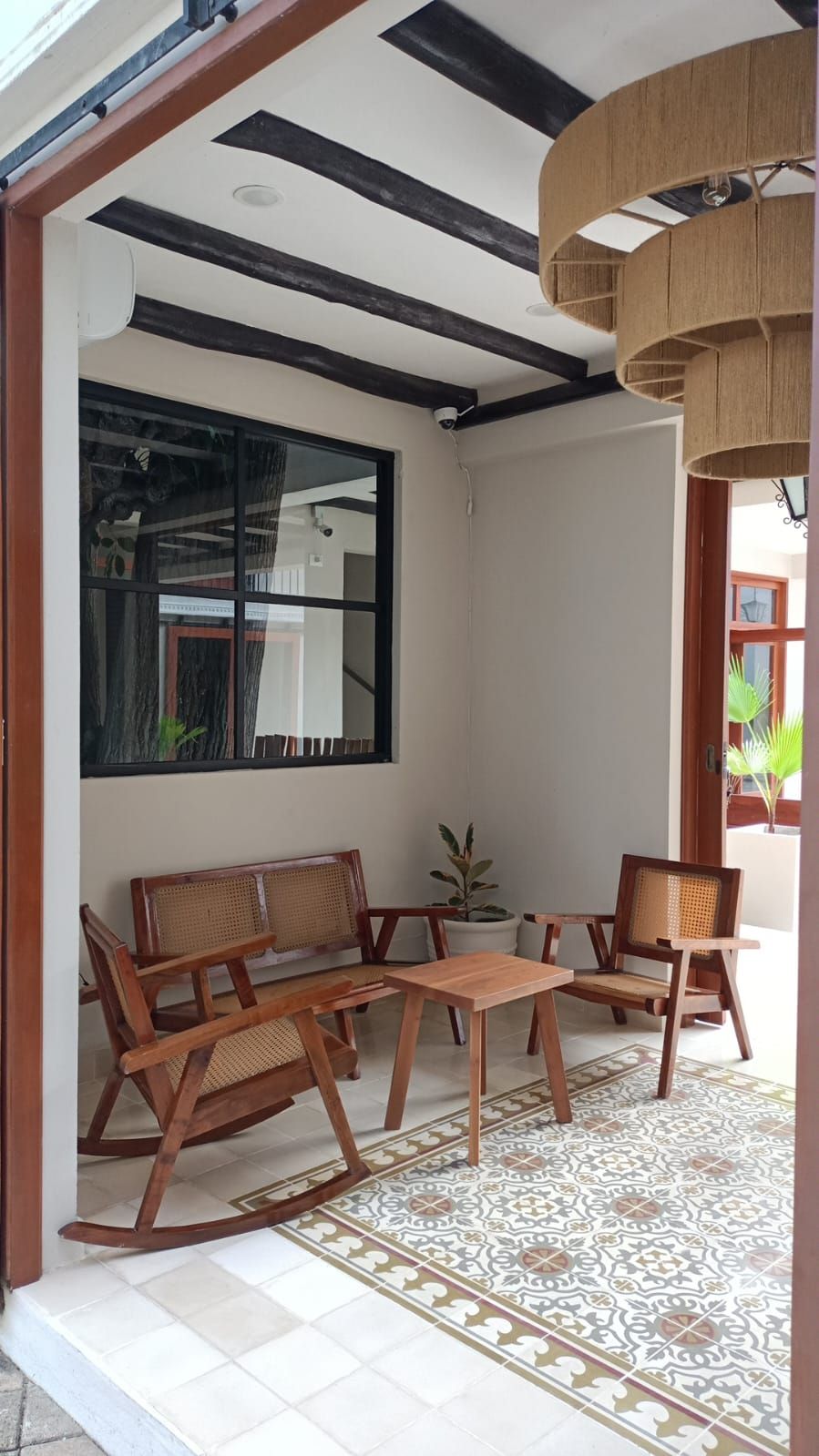 Un espacio al aire libre con techo, mobiliario de madera y suelo estampado.