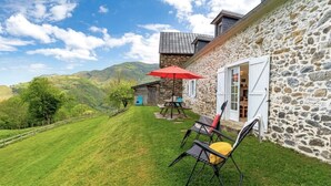 A stone building with a patio, outdoor seating, and a view of the hills. - Artegia - Sainte-engrace (SAINTE-ENGRACE)