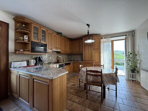Una cocina con armarios de madera, una isla central y una mesa de comedor con sillas.