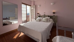 A bedroom with a large bed, a dresser, a mirror, and a window with a view. - Aguerrea - Macaye - Gîte (MACAYE)
