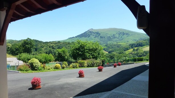 A road with potted plants and a mountainous landscape in the background. - Aguerrea - Macaye - Gîte (MACAYE)