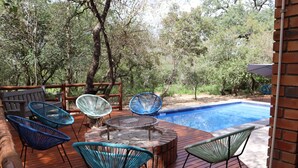 A wooden deck with outdoor seating and a swimming pool.