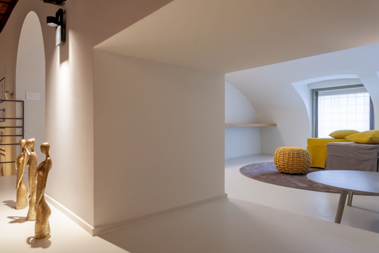 Ein modernes Interieur mit gewölbter Decke, einer Sitzecke mit Kissen und einem kleinen runden Tisch.