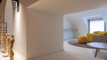 Ein modernes Interieur mit gewölbter Decke, einer Sitzecke mit Kissen und einem kleinen runden Tisch.