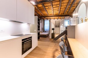A modern kitchen with white cabinetry, a built-in oven, and a wooden ceiling. - VIA SIMONE MAYR, 2 · Bergamo città Alta - appartamento di charme (Bergamo)
