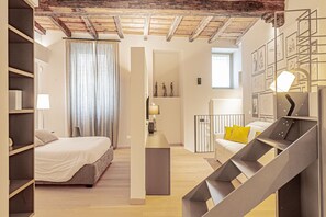 A modern bedroom with a bed, a desk, and a staircase. - VIA SIMONE MAYR, 2 · Bergamo città Alta - appartamento di charme (Bergamo)