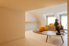A modern interior with a round table, a statue, and a yellow ottoman. - VIA SIMONE MAYR, 2 · Bergamo città Alta - appartamento di charme (Bergamo)