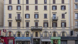 A multi-story building with ground-floor shops, including a bar and a clothing store. - Buenos Aires 49 – Lungo la via dello shopping (Milano)