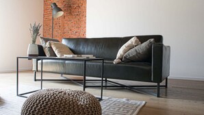Una sala moderna con un sofá de cuero, una mesa de centro y una lámpara.