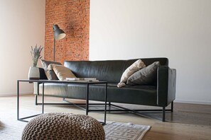 Una sala moderna con un sofá de cuero, una mesa de centro y una lámpara.