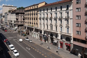 A street view of a row of historic buildings with a hotel and various shops. - CASATI, 2 · Glamour in città tra shopping e vita notturna (Milano)
