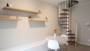 A modern interior with a spiral staircase, white furniture, and wooden shelves. - CASATI, 2 · Glamour in città tra shopping e vita notturna (Milano)