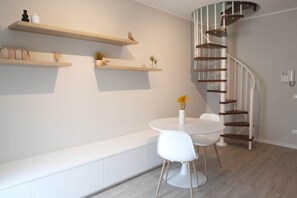 A modern interior with a spiral staircase, white furniture, and wooden shelves. - CASATI, 2 · Glamour in città tra shopping e vita notturna (Milano)