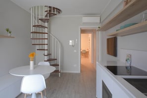 A modern kitchen with a built-in stove, white cabinetry, and a spiral staircase leading to another level. - CASATI, 2 · Glamour in città tra shopping e vita notturna (Milano)