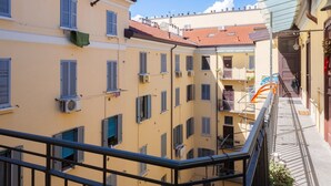Un immeuble à plusieurs étages doté de balcons, de climatiseurs et surplombant un ciel dégagé.