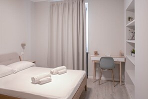 A bedroom with a bed, a desk, a chair, and a shelf with plants. - CASATI, 2 · Glamour in città tra shopping e vita notturna (Milano)