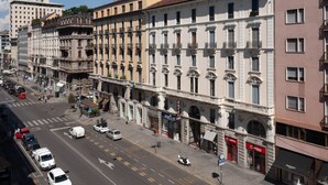 Une vue de rue d’une rangée de bâtiments historiques, avec un hôtel et divers commerces.
