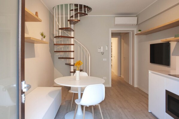 A modern kitchen with white cabinetry, a built-in oven, and a flat-screen TV mounted above the counter. - CASATI, 2 · Glamour in città tra shopping e vita notturna (Milano)