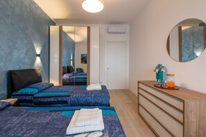 A bedroom with a bed, bedside tables, a mirror, and a wardrobe.