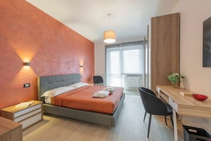 Une chambre à coucher moderne avec un lit, une table de chevet et un bureau avec une chaise.