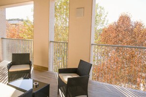 A balcony with wicker furniture, a small table, and a view of trees. - GOVONE, 78 · Ampio e luminoso appartamento con terrazza (Milano)