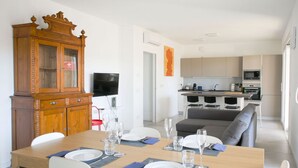 A dining area with a wooden table set for four, a cabinet, and a television.