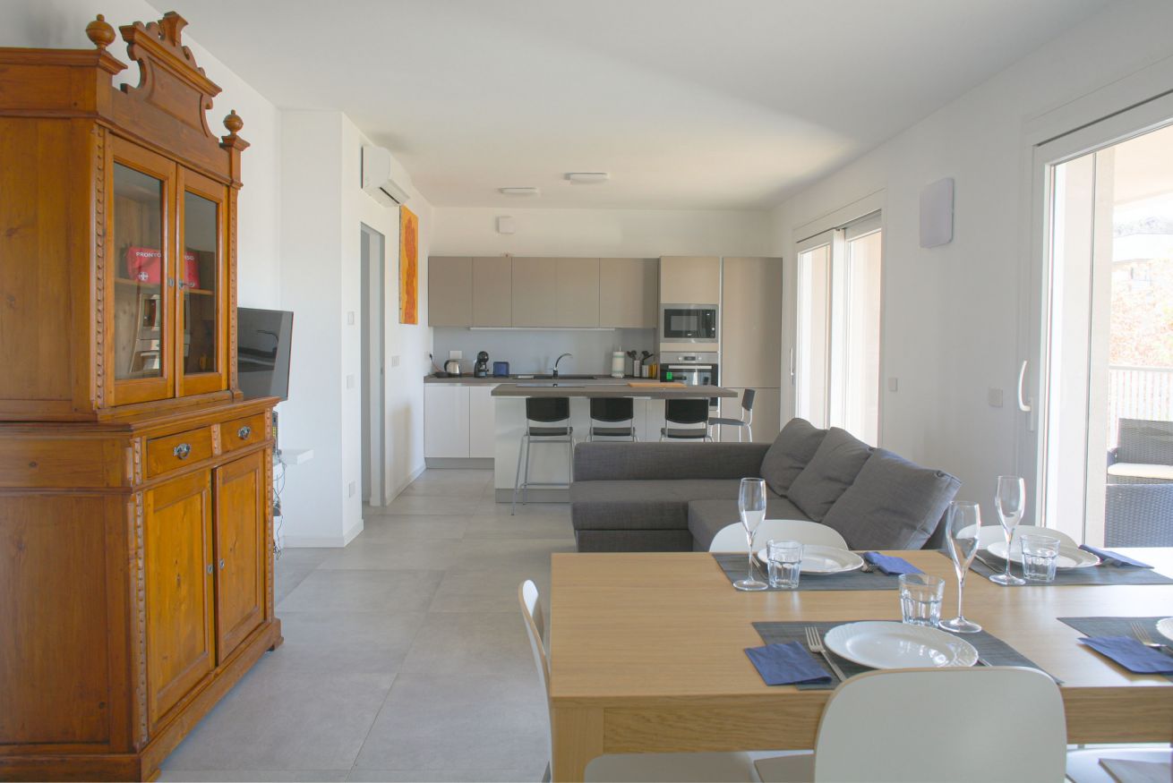Una cocina moderna con comedor, un armario de madera y un sofá.