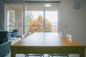 Une salle de conférence avec une longue table, des chaises et un balcon donnant sur un paysage aux couleurs automnales.