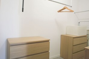 A room with a wooden dresser, a hanging coat rack, and a radiator. - GOVONE, 78 · Ampio e luminoso appartamento con terrazza (Milano)