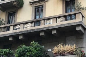 A multi-story building with balconies, windows, and some greenery. - Guercino, 8 – Renovated design apartment (Milano)