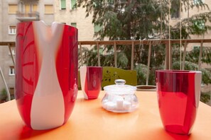 Una mesa con tres recipientes de vidrio rojos y un frasco de vidrio con cubos de azúcar.