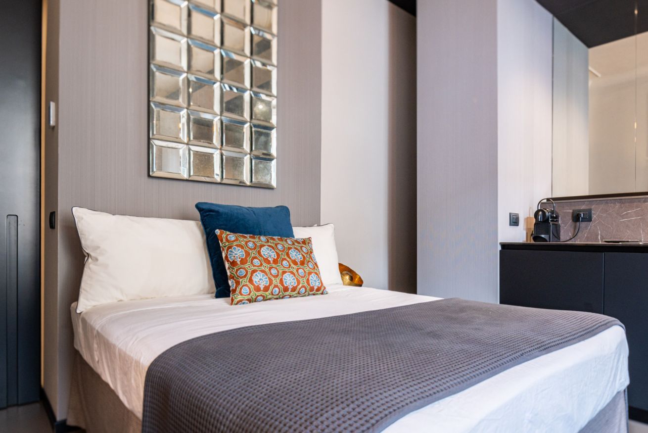 Ein Hotelzimmer mit Bett, großem Spiegel und modernem Design.