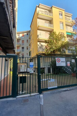 Un edificio residencial con puerta de acceso, varios pisos y balcones.