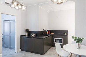 A modern kitchen with a central island, a microwave, and a sink.