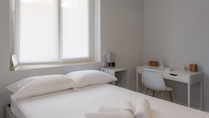 Un dormitorio con cama, escritorio y silla.