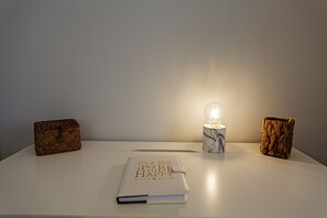 A table with a notebook, a lamp, and two decorative boxes.