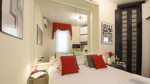 Une chambre d’hôtel avec un grand lit, une table de chevet avec une lampe, un miroir et une armoire.