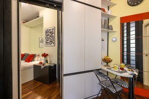 A compact room with a bed, a small table with chairs, and a dining area with a table and chairs. - PONTACCIO, 4 - Atmosfere di charme in pieno centro (Milano)