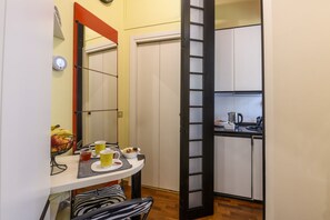 A compact kitchen with a dining area, a white cabinet, and a small table with breakfast items. - PONTACCIO, 4 - Atmosfere di charme in pieno centro (Milano)