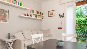 Un salon moderne comprenant un canapé, une table à manger, une bibliothèque et une petite table d’appoint.