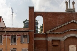 Un edificio de ladrillo con un amplio ventanal arqueado y una estatua en la parte superior.