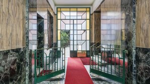 A marble hallway with a red carpet leading to a staircase. - Venini 14 - Tra Centrale e Buenos Aires (Milano)