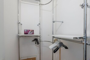A metal shelving unit with a hanging rack, a box of laundry detergent, and a pair of scissors. - Verona 12, Porta Romana district (Milano)