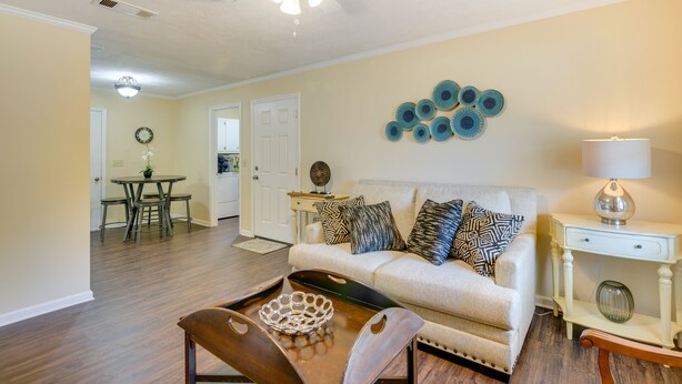 A living room with a sofa, coffee table, and a dining area with a table and chairs. - Bring the Whole Alumni Crew Close to Ole Miss (Oxford)