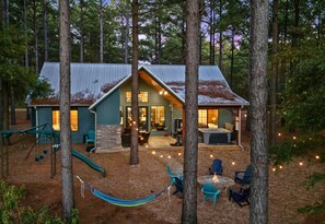 A cabin with a metal roof, a porch with outdoor seating, and a hammock. - Secluded Hot Tub Retreat for Families and Friends (Broken Bow)