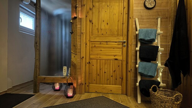 Eine Holztür, ein Handtuchhalter mit Handtüchern, ein gewebter Korb und eine Fußmatte.
