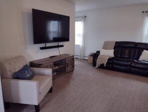 Relax in this stylish living room with a flat-screen TV, comfortable sofas, and a cozy entertainment unit.
