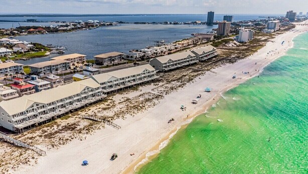 An aerial view of a coastal hotel with multiple buildings, a sandy beach, and clear turquoise waters. - SunnySide Up ~ Beach & Bay!! (Pensacola Beach)